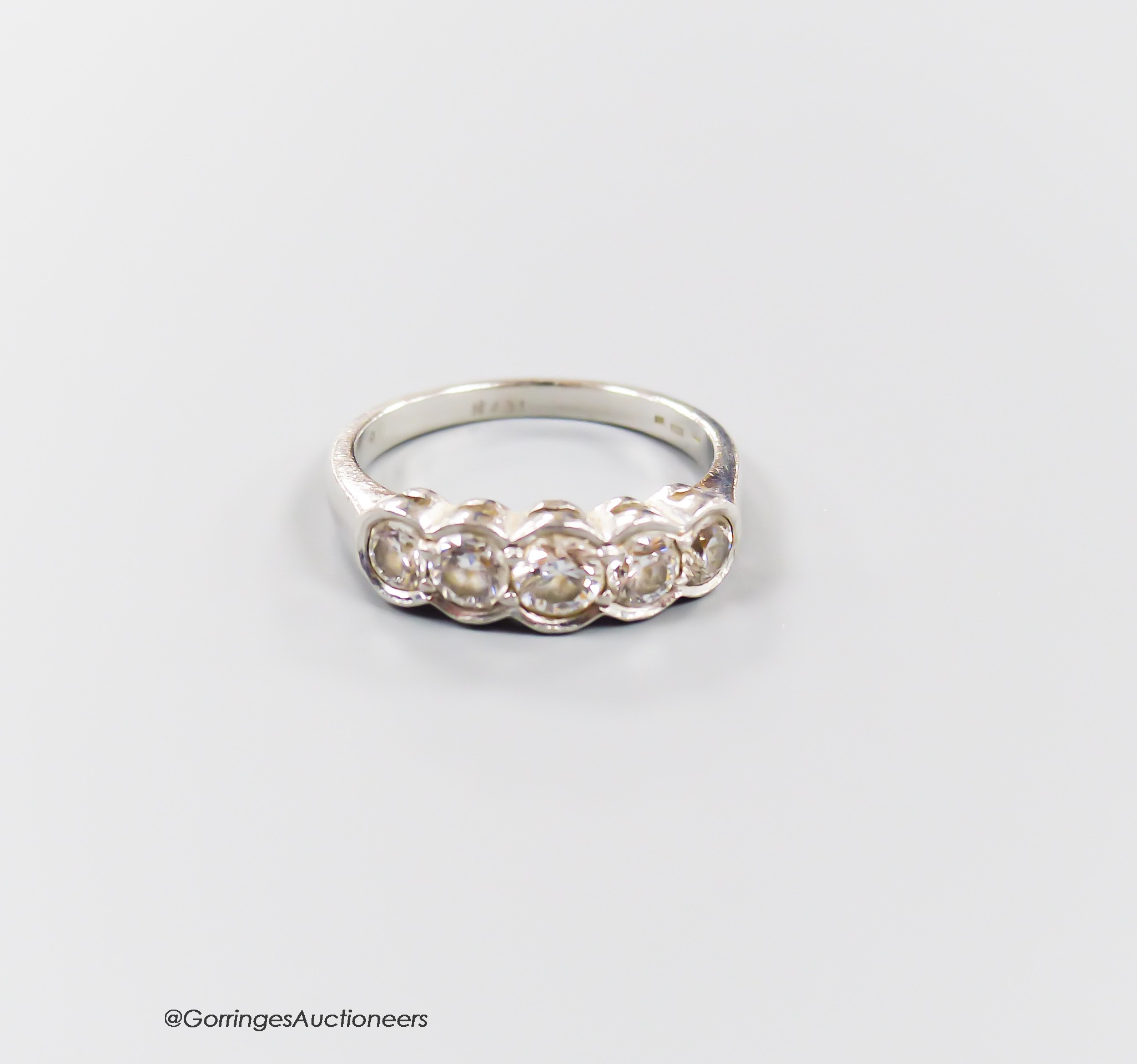 A modern platinum and graduated five-stone diamond half hoop ring, size L/M, gross 5.2 grams.